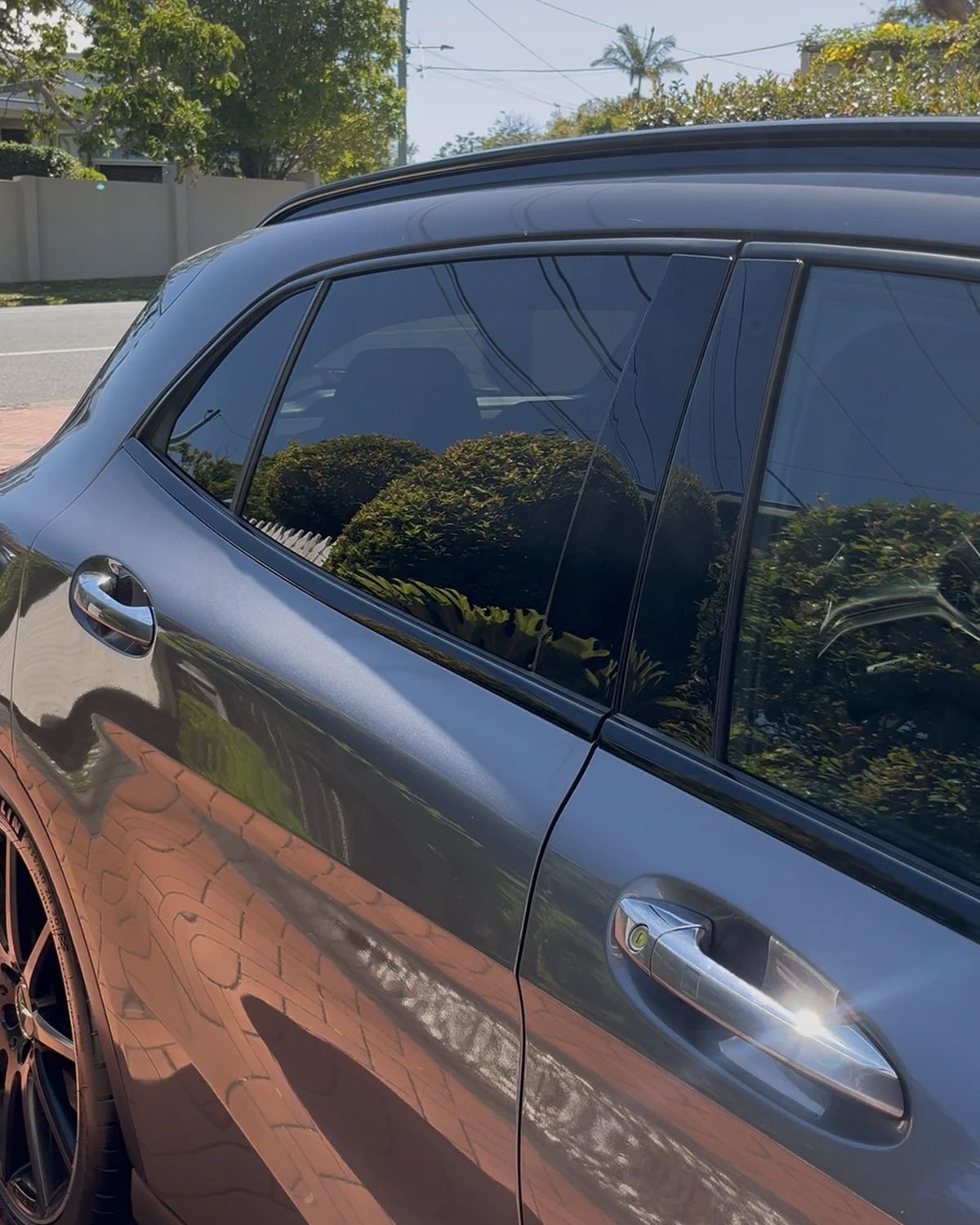 Grey Mercedes side and doors after a detail, with the garden reflected in the paint
