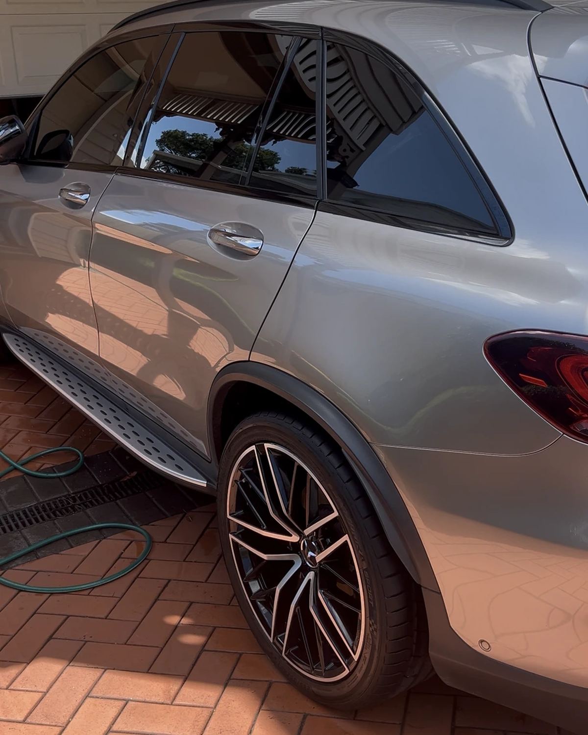 Silver Mercedes SUV after a detail, side view on a brick driveway